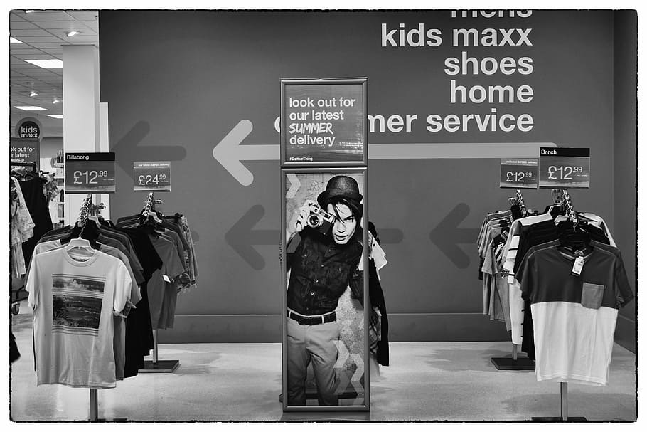 greyscale photo, hanging, clothes, signage, camera, advertising, people, space, business, design
