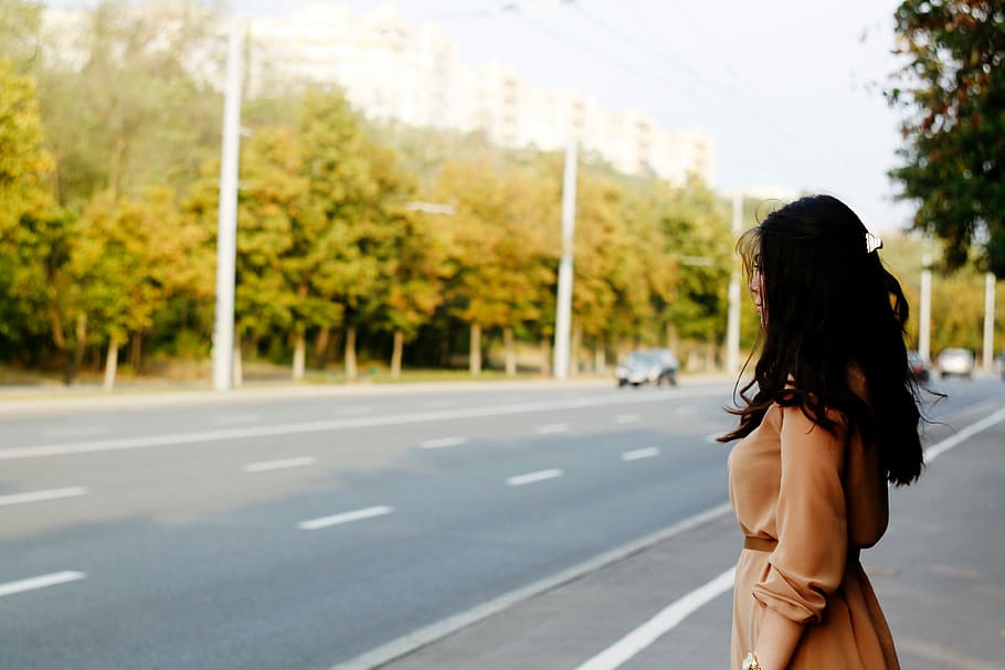 mulher, marrom, vestido, em pé, estrada, carro, verde, árvores, cinza, nuvens
