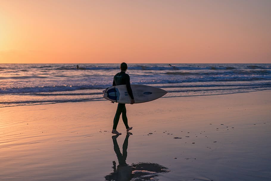 silhouette photography, man, walking, beach, holding, surfboard, sunset, sea, water, dusk