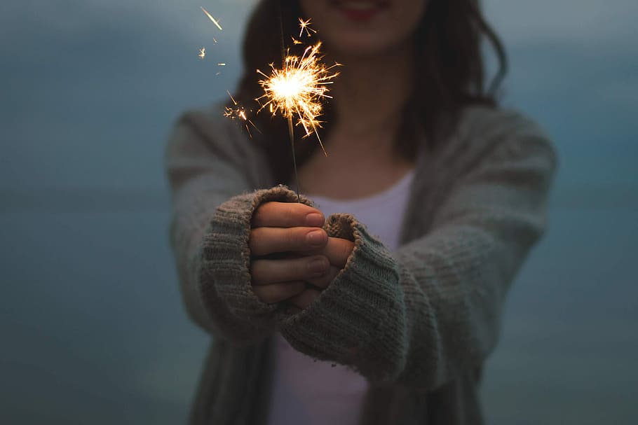 shallow, focus photography, woman, gray, knitted, cardigan, holding, fireworks, shallow focus, photography