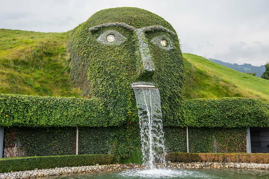 green outdoor fountain, waterfall, artwork, sculpture, figure, wattens, crystal worlds, tyrol, exhibition, water