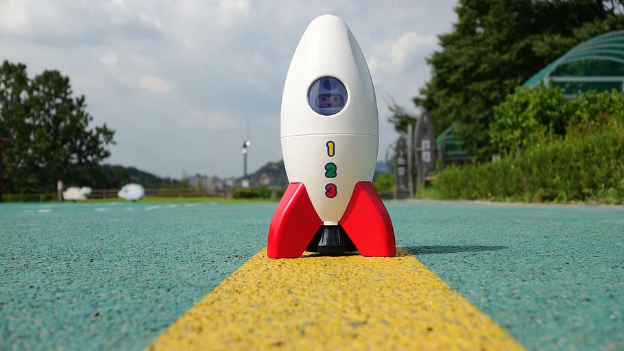 white, toy rocket, cement pavement, rocket, toy, playmobil, the ship, day, tree, selective focus