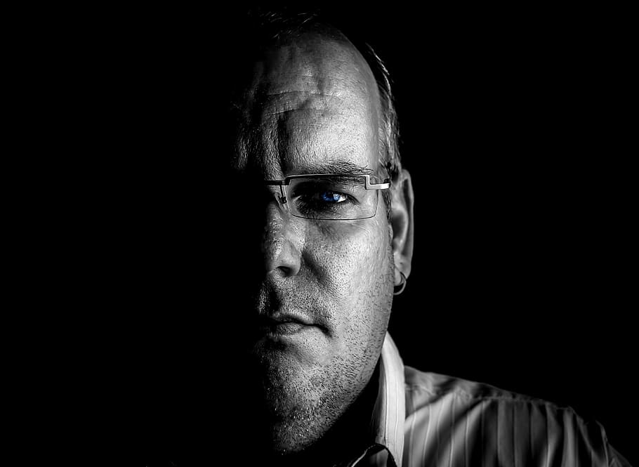 grayscale photography, man, face, mysterious, portrait, shadow, headshot, one person, studio shot, serious