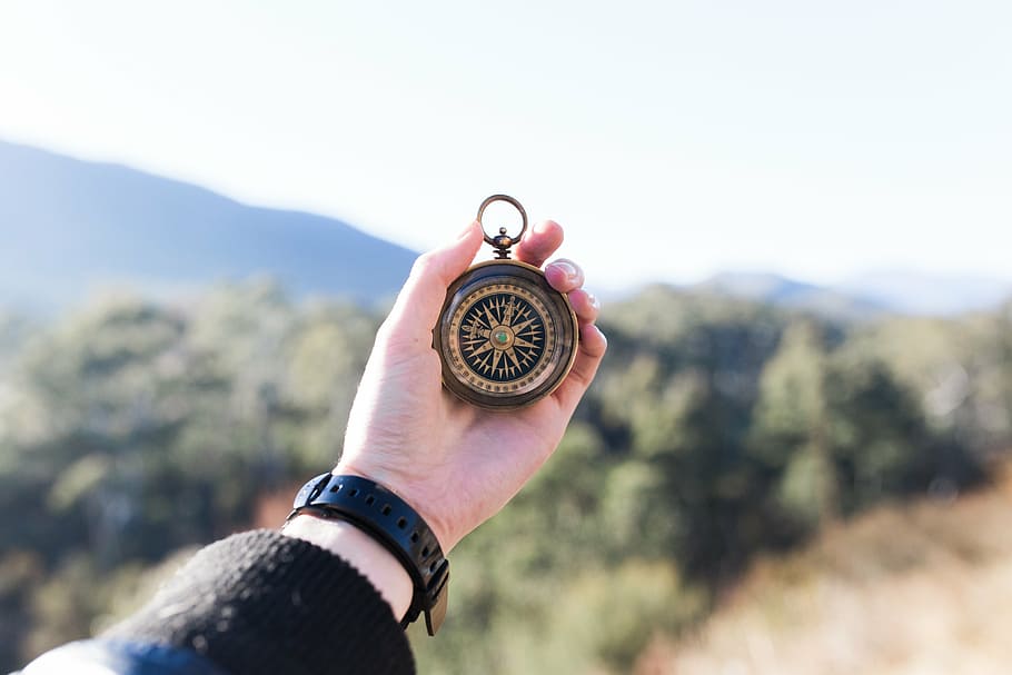 person, holding, gold-colored compass, round, compass, metal, hand, palm, travel, outdoor