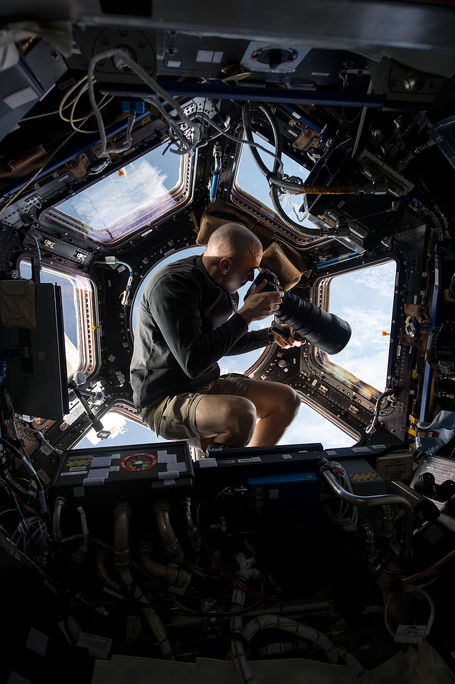 man, holding, dslr camera, astronaut, space station, cupola, flight engineer, photography, earth, nasa