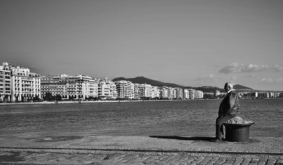 homem, sentado, preto, poste de aço, banco, praia, escala de cinza, foto, Grécia, edifícios