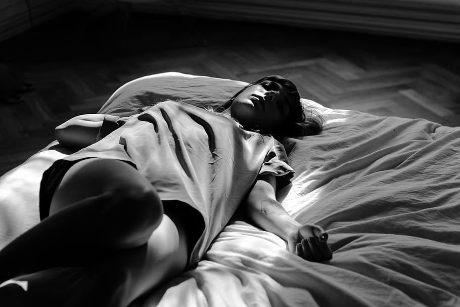 grayscale photography, woman, wearing, t-shirt, laying, bed, person, sleeping, lying down, lying on back