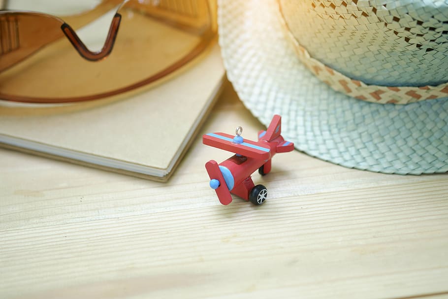 red, blue, toy plane, brown, safety glasses, teal straw hat, airplane, toy, eyeglasses, hat