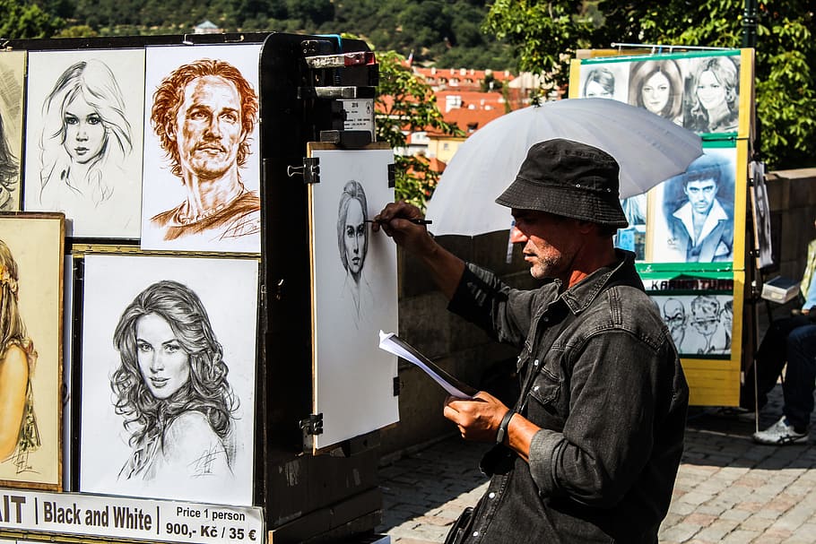 man doing potrait, artist, painter, charles bridge, prague, street artist, portrait, girl, tourists, colors