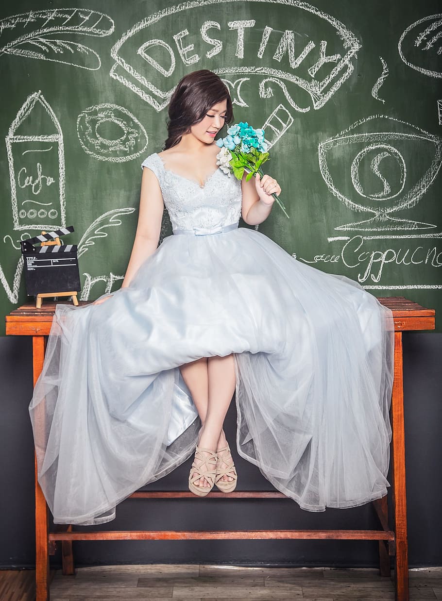 woman, wearing, grey, satin sleeveless ball gown, holding, blue, white, hydrangea flowers bouquet, sitting, brown