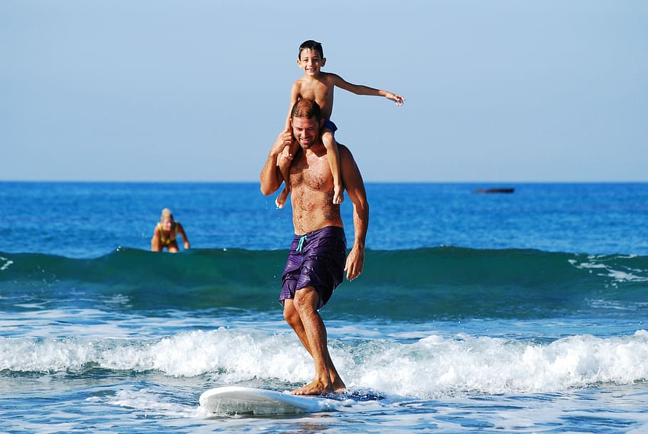 homem, carregando, filho, montando, branco, prancha de surf, praia, seu filho, surfando, prancha