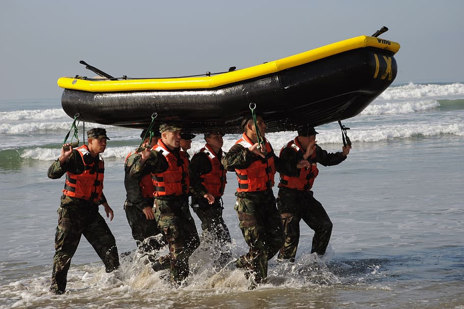 grupo, homens, carregando, preto, amarelo, barco inflável, barco, trabalho em equipe, treinamento, exercício
