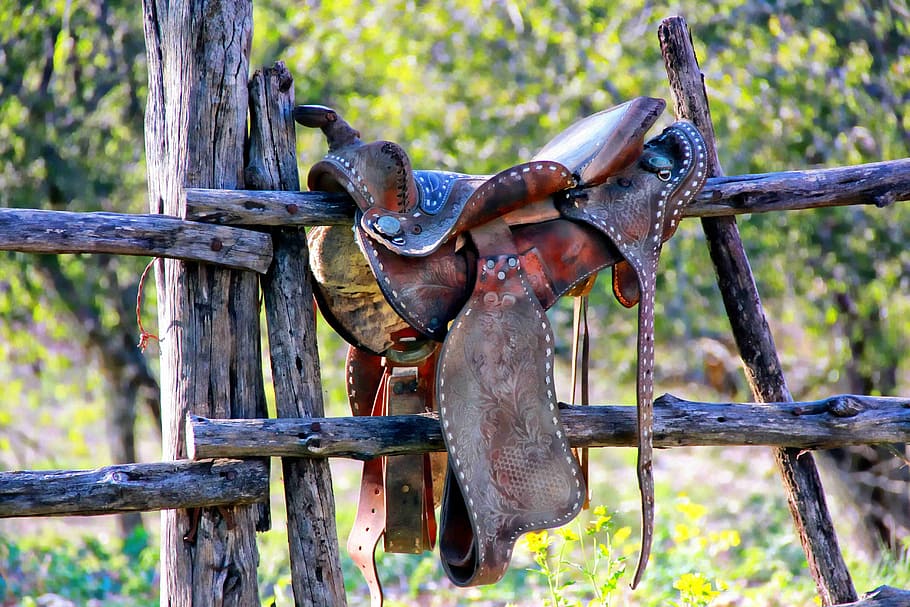 brown, leather horse saddle, wooden, fence, daytime, weathered saddle, dude ranch, texas, wood - material, focus on foreground