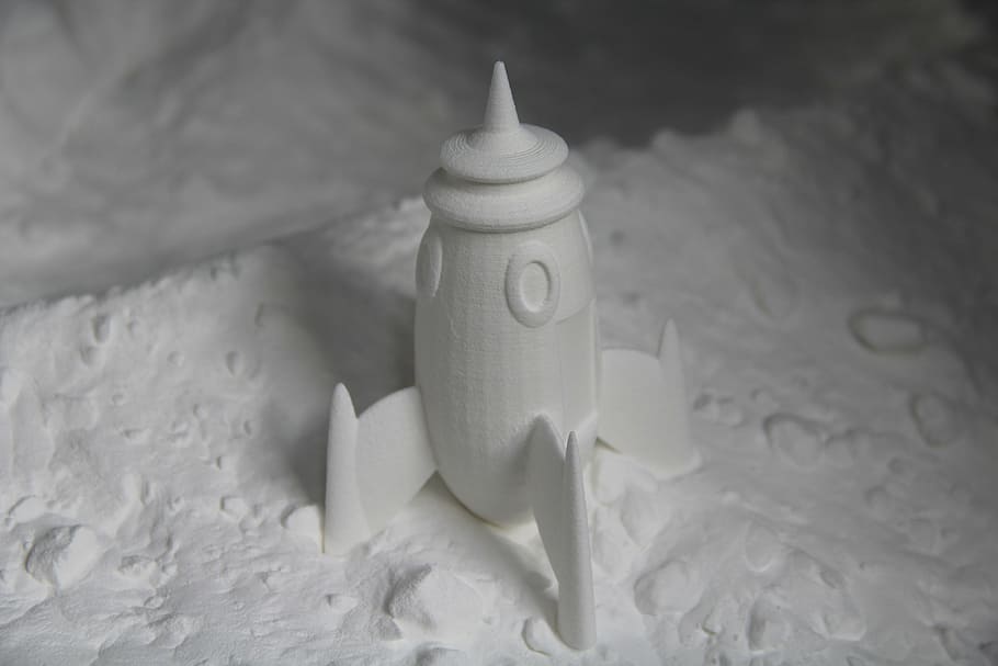 white, rocket figurine, sand, rocket, printing, 3d, food, indoors, close-up, white color