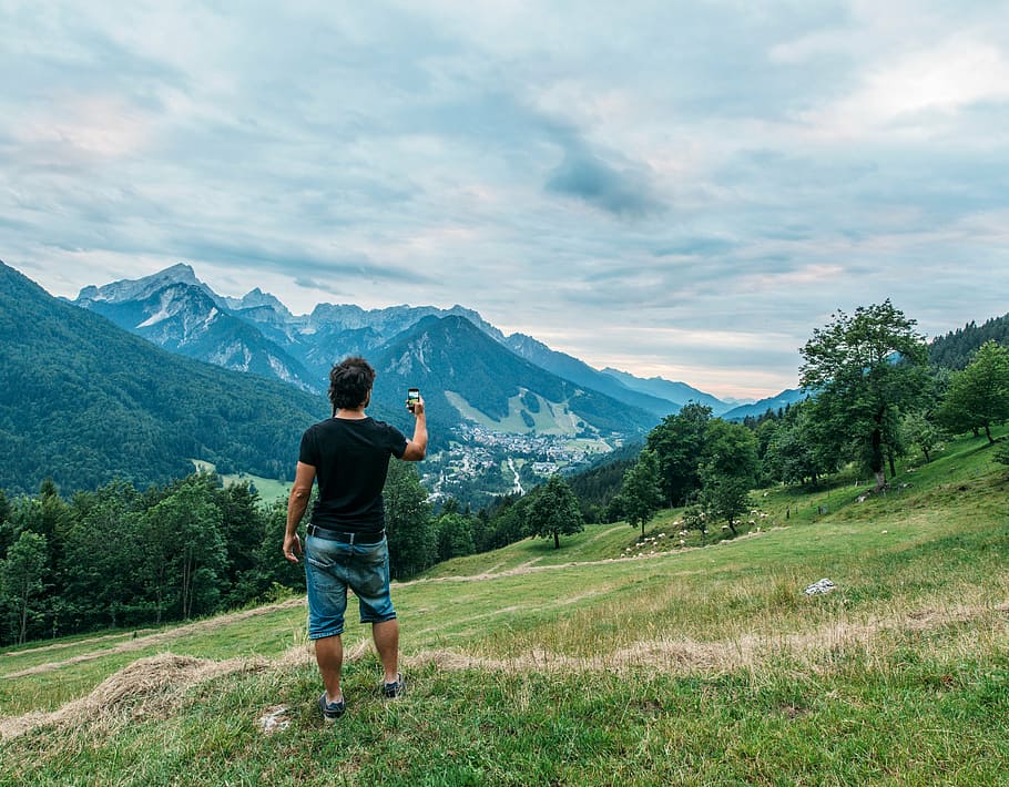 homem, de pé, verde, campo de grama, segurando, preto, smartphone Android, Alpes da montanha, natureza, paisagem