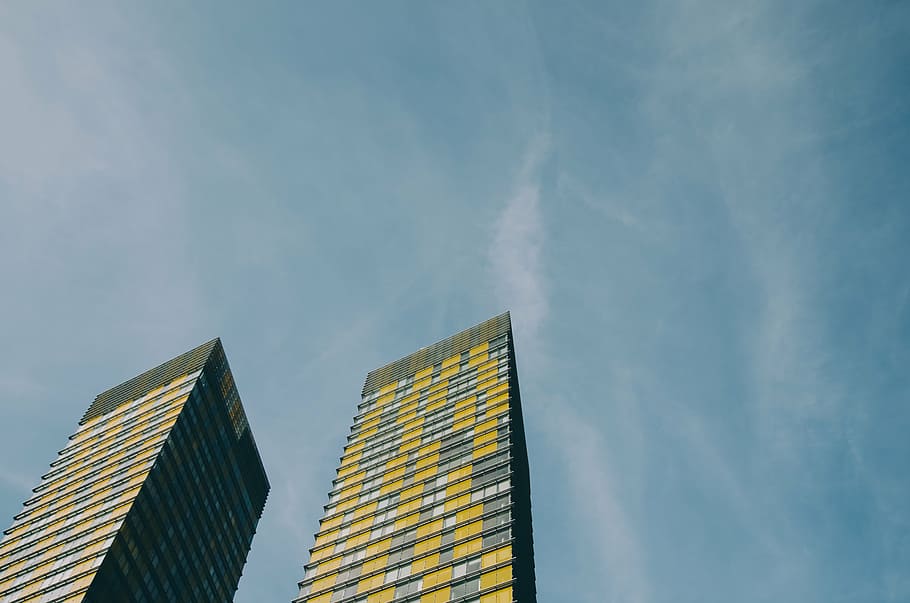 fotografía de ángulo bajo, amarillo, edificio, arquitectura, infraestructura, azul, cielo, rascacielos, torre, día
