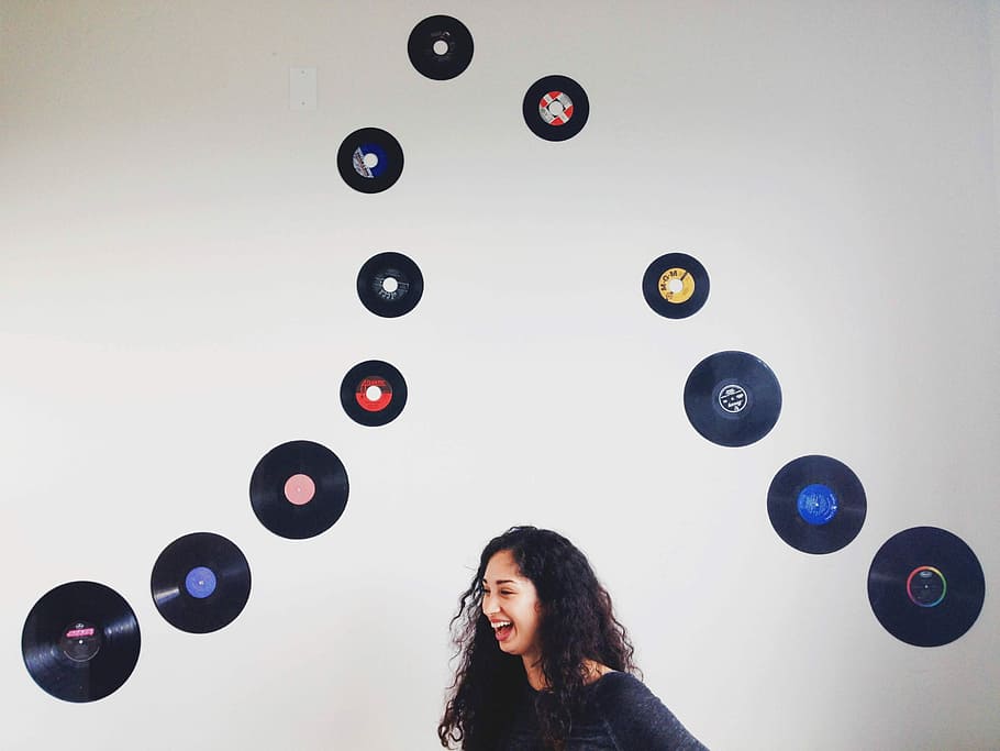 woman, black, top, standing, laughing, nest, disc wall decors, woman in black, black top, disc