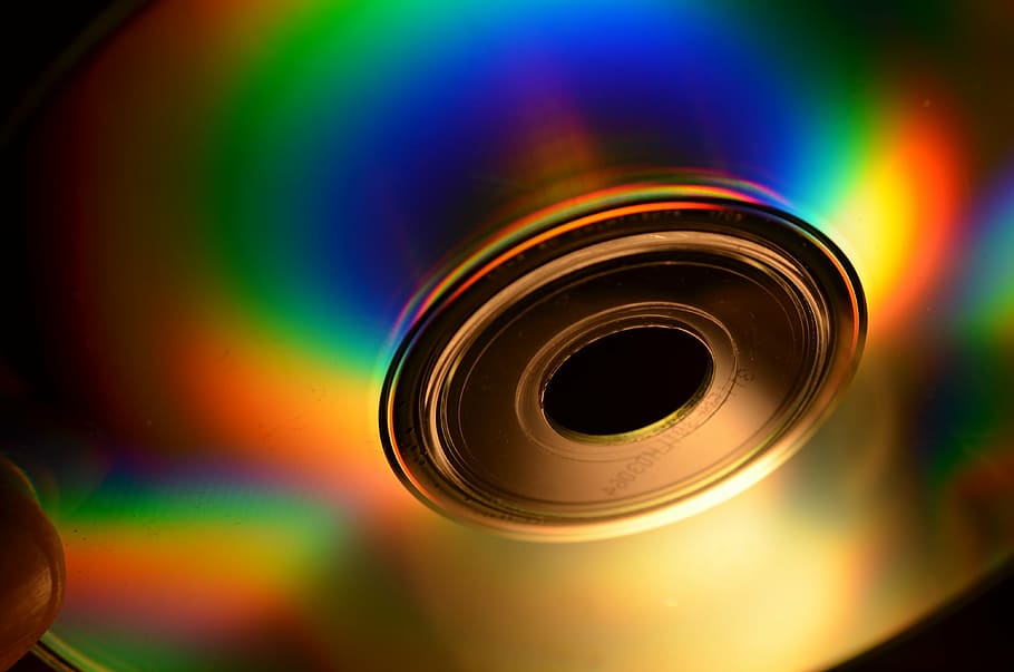 person holding disc, cd, cd cd rom, computer, disk, hard drive, multi colored, close-up, rainbow, geometric shape