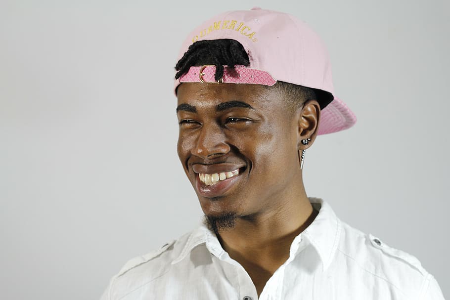 man, wearing, pink, snapback cap, looking, towards, left, rapper, happy, laughing