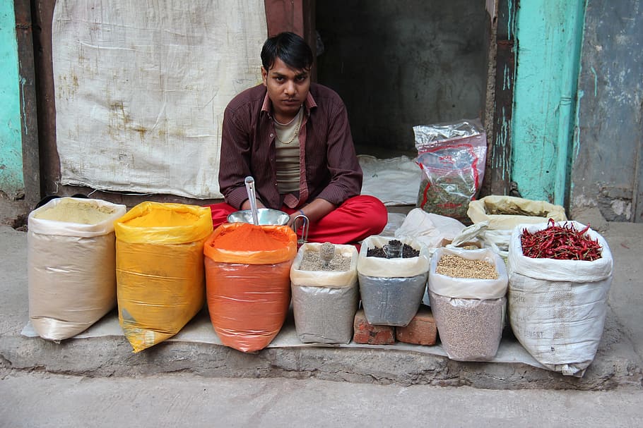 man, sitting, front, assorted-color sacks, seller, indians, india, delhi, market, one person