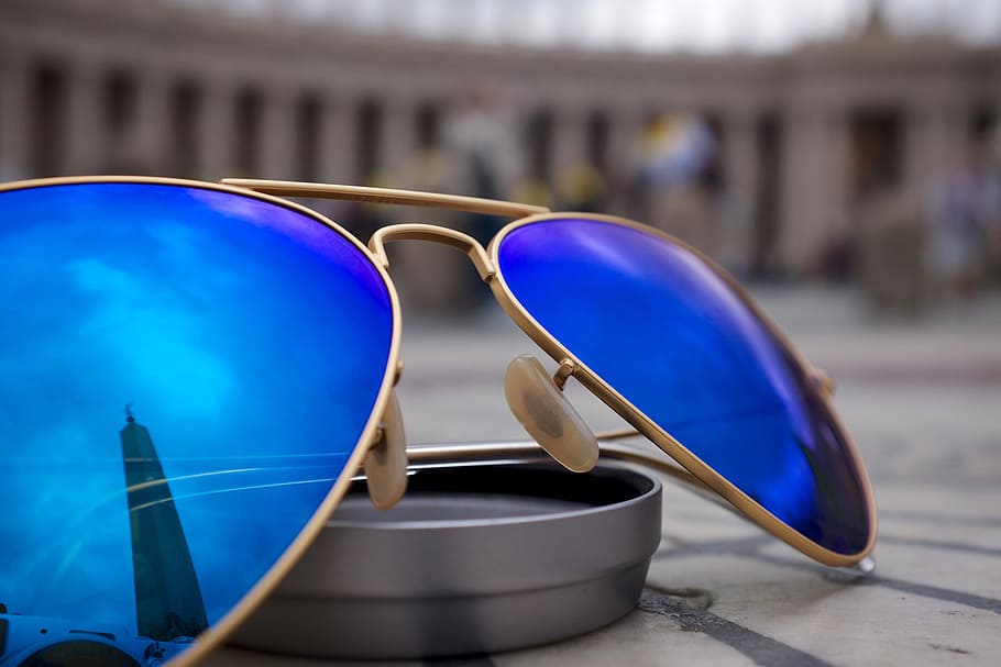 selective, focus photo, blue, lens aviator-style sunglasses, gold-colored frames, round, gray, case, sunglasses, reflection