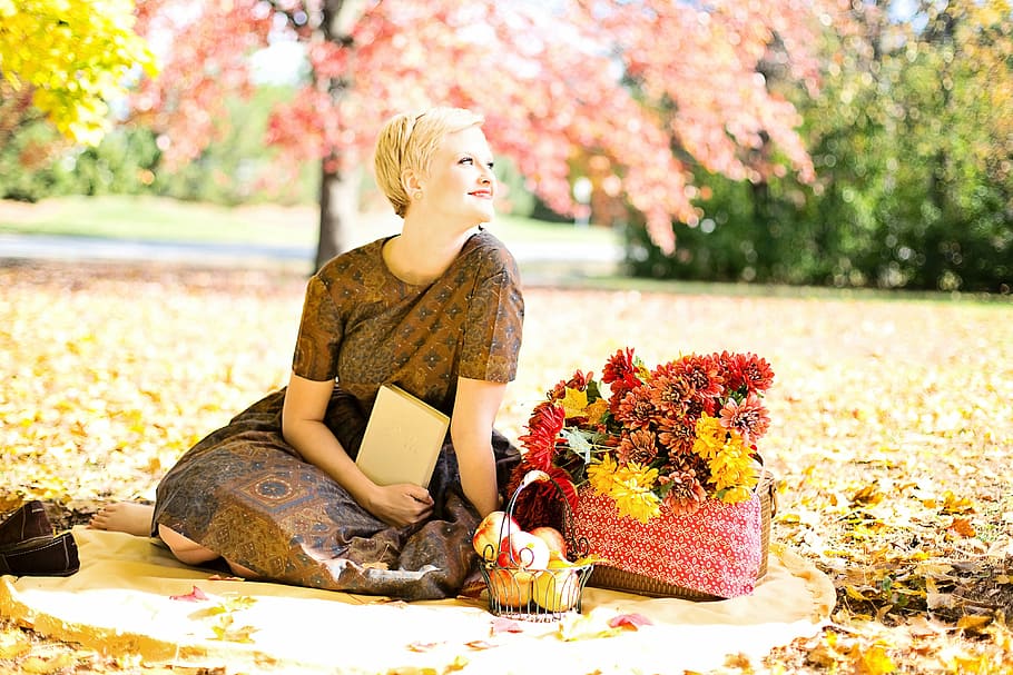 woman, wearing, brown, floral, dress, sitting, basket, red, yellow, petaled flowers