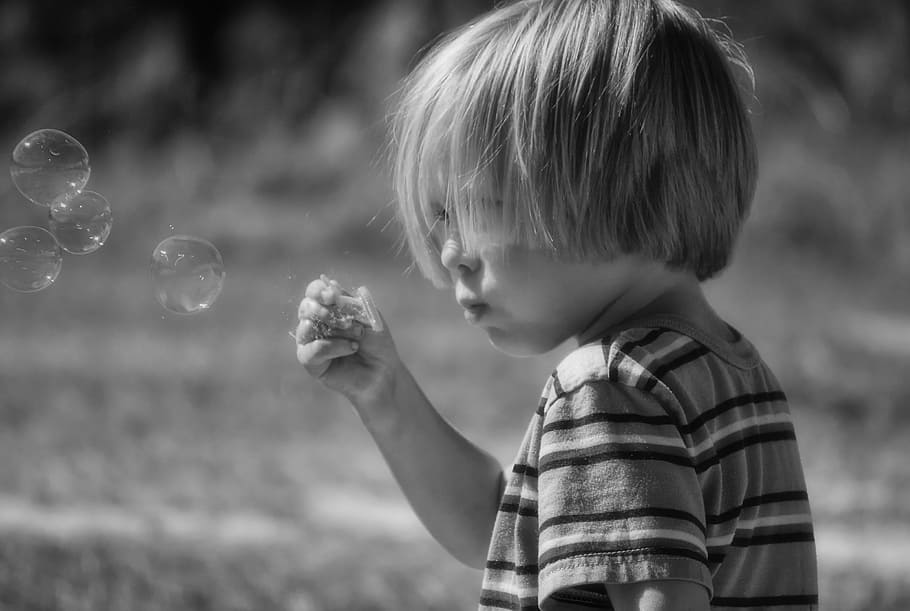 grayscale photograph, toddler, blowing, bobbles, soap bubbles, boy, bubbles, child, fun, happy