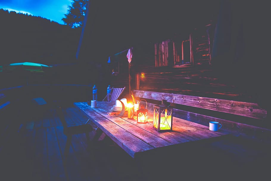 lightened, candle, inside, candle holder, brown, wooden, table, picnic table, deck, backyard