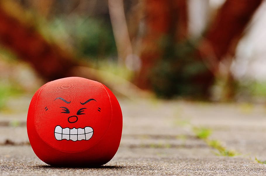red, emoji toy, gray, pavement, smiley, rage, evil, sour, funny, sweet