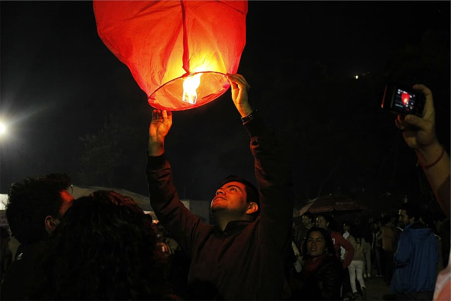 person, holding, paper air lantern, photography, man, lantern, fire, dark, night, people