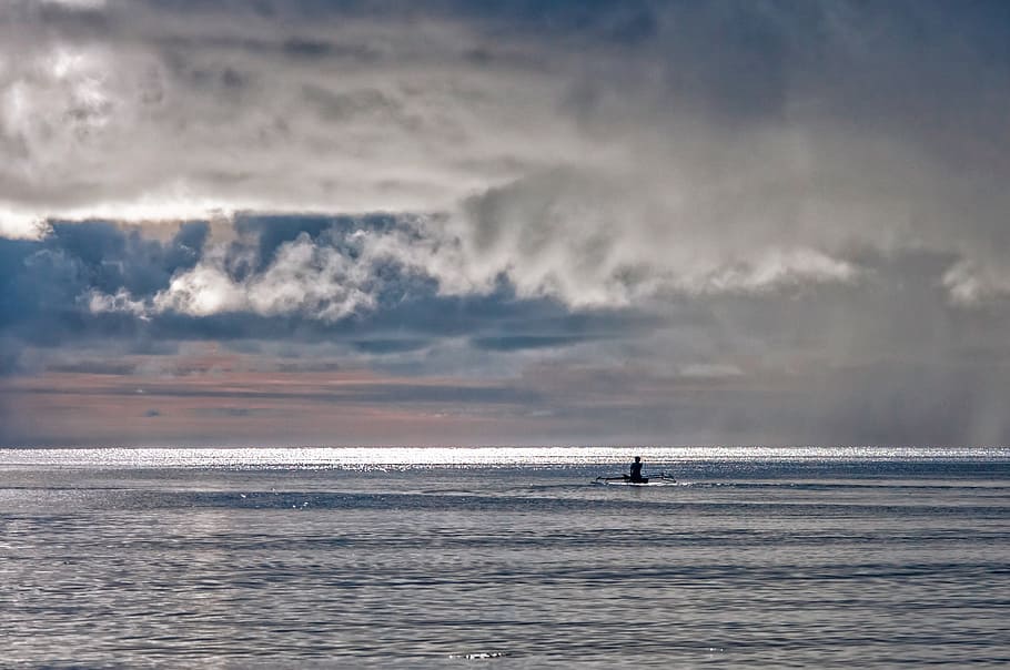 silhouette photo, person, canoe, sea, boat, storm premonition, loneliness, anxiety, halmahera islands, indonesia