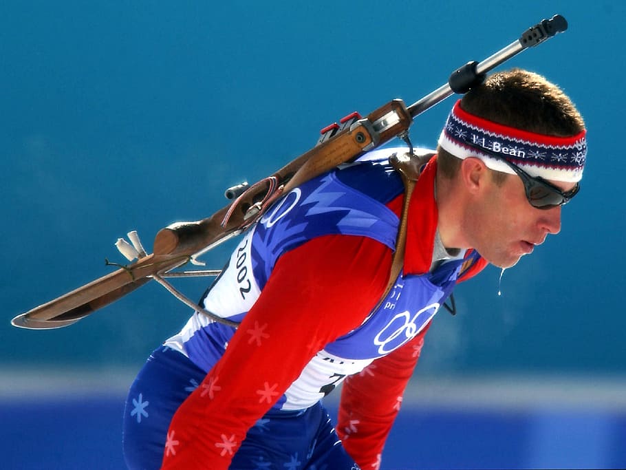 man, wearing, blue, white, top, carrying, rifle, biathlon, competitor, athlete