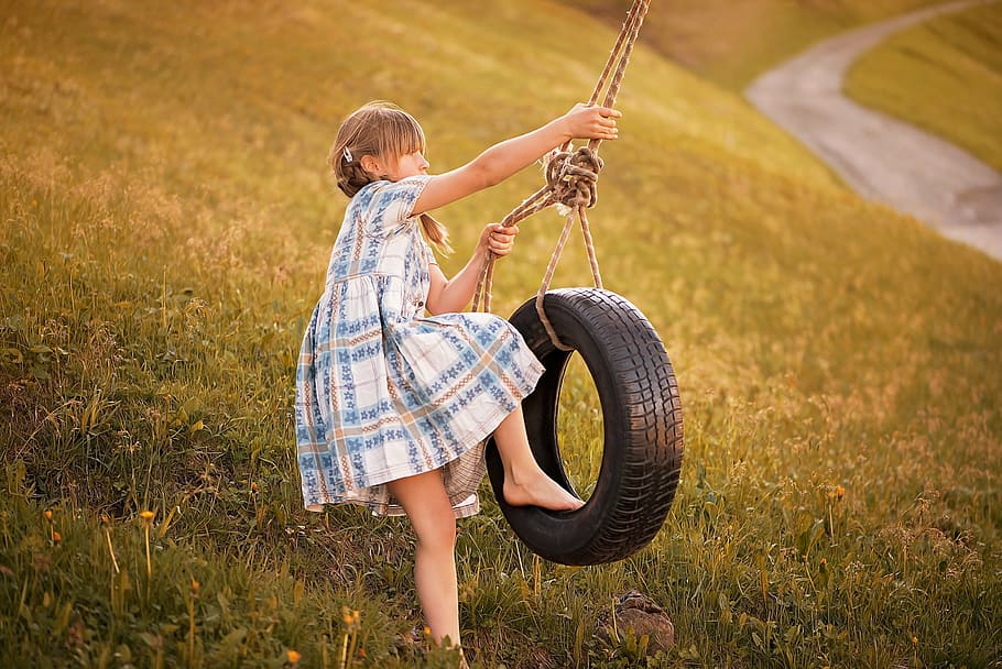 girl, ride, swing vehicle tire, green, grass field, person, human, child, play, rock