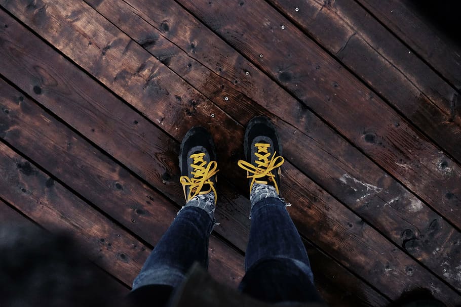 person, wearing, black-and-yellow, sneakers, brown, wooden, floor, man, black, yellow
