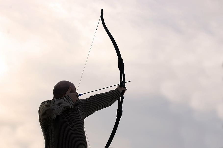 person, wearing, black, long-sleeve, top, holding, long, bow, archer, arrow