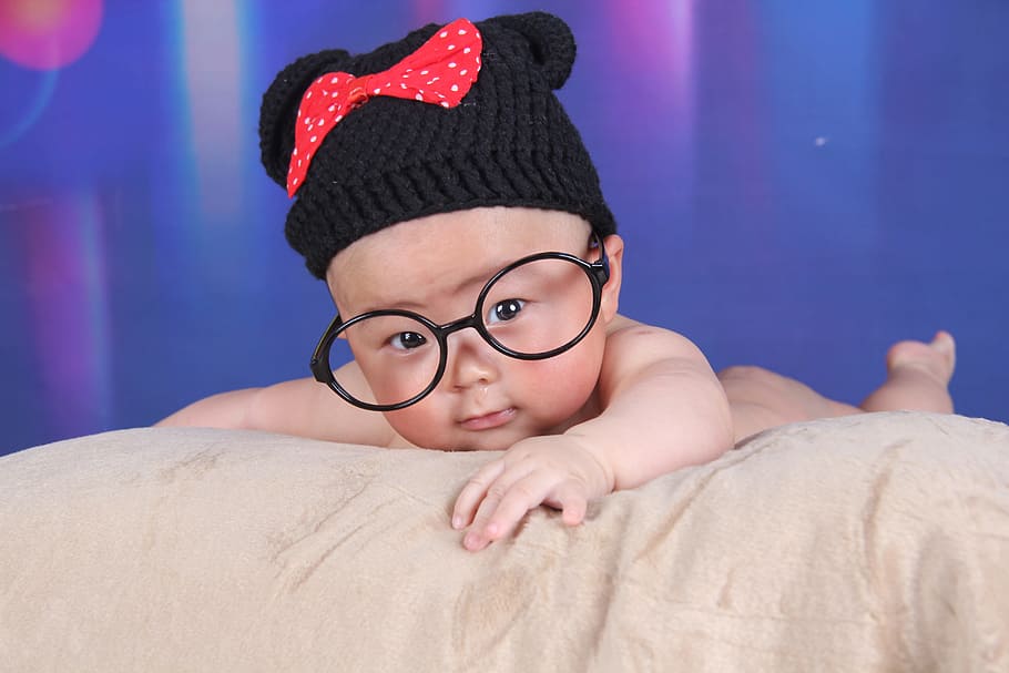 baby, wearing, black, red, knitted, hat, eyeglasses, lying, bed, Minnie Mouse