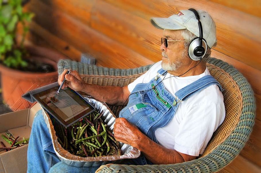 grandfather, sitting, wicker, brown, armchair, white, using, tablet computer, ipad, farm