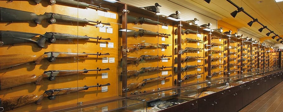 weapons, stand with arms, weapon shop, large group of objects, indoors, in a row, shelf, yellow, wood - material, order
