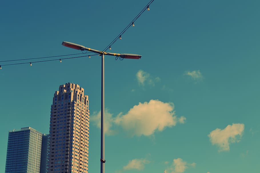 blue, sky, clouds, lamp post, string lights, buildings, towers, high rises, architecture, city