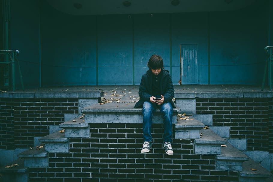 boy, wears, black, zip-up jacket, alone, child, sitting, stairs, young, one person