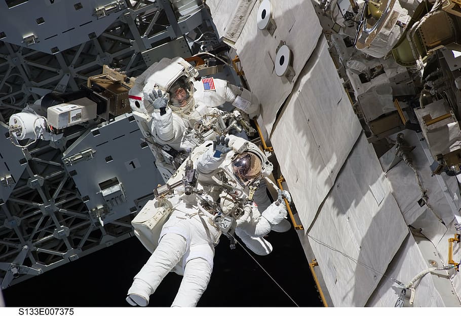 two astronauts, spacewalk, space shuttle, discovery, tools, suit, pack, tether, floating, job
