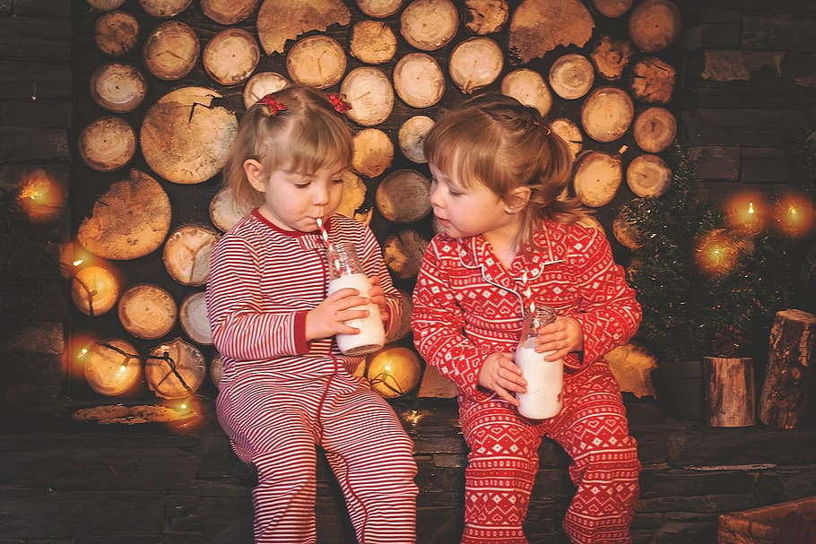 dois, meninas, vestindo, pijama footie, bebendo, bebida, crianças de natal, biscoitos e leite, natal, biscoitos