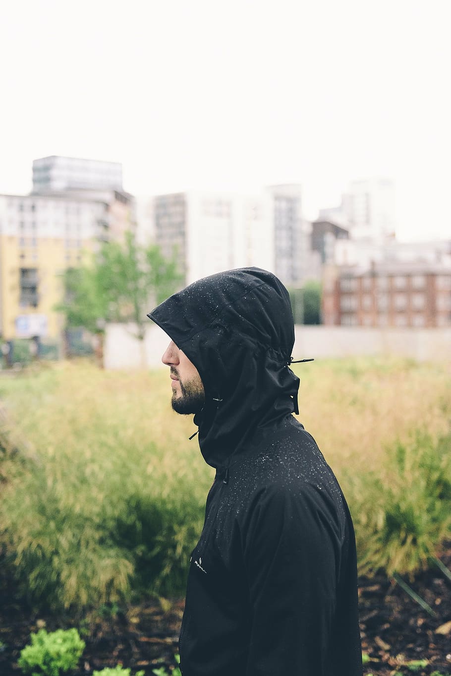 man, walking, street, day time, wearing, black, hoodie, profile, raincoat, raining