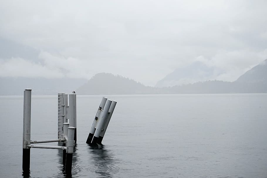 white, metal post, body, water, mountain, daytime, grayscale, metal, posts, sea