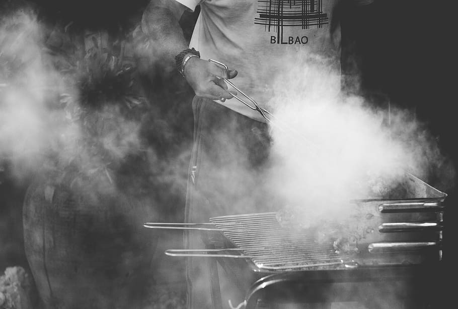 grayscale photo, person grilling, grill, smoke, people, man, cook, meat, charcoal, outdoor