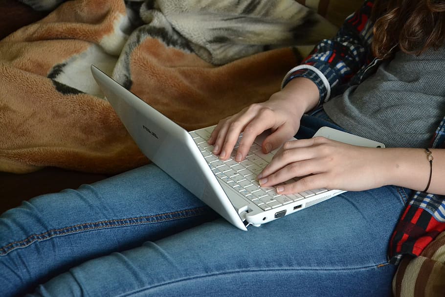 woman, wearing, gray, long-sleeved, shirt, blue, jeans, white, laptop, lap