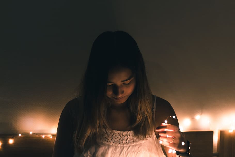 woman, wearing, white, camisole, holding, brown, string light, painted, wall close-up photo, people