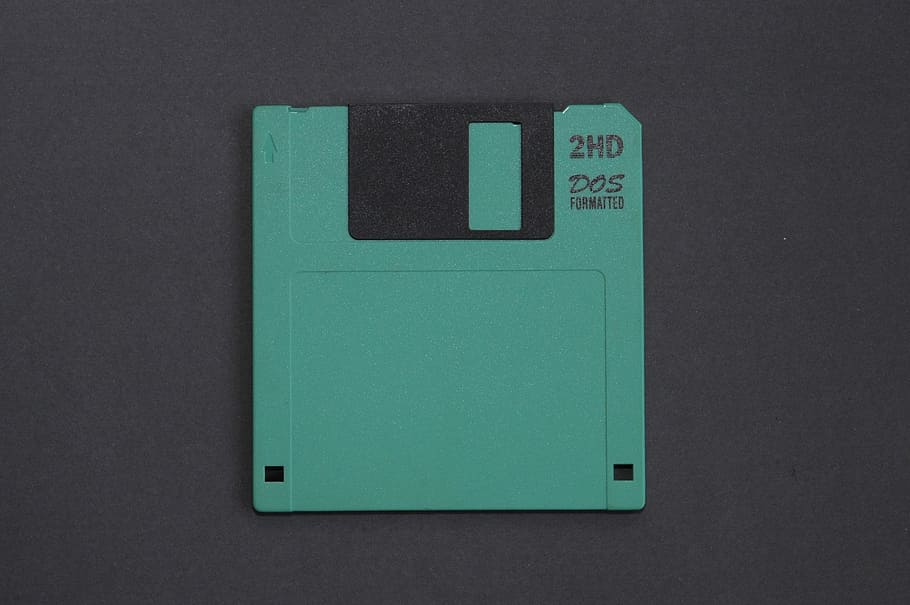 green floppy disk, old technology, storage, green color, gray, gray background, indoors, studio shot, single object, close-up