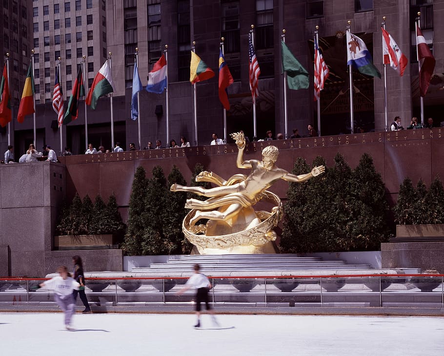 dos, niño, patinaje, al lado, estatua de color bronce, banderas, durante el día, ciudad de nueva york, rockefeller center, patinaje sobre hielo
