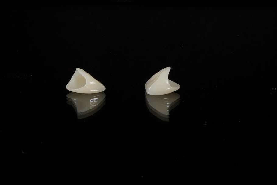 two white tools, dental, porcelain tooth, wax, black background, studio shot, indoors, white color, copy space, still life